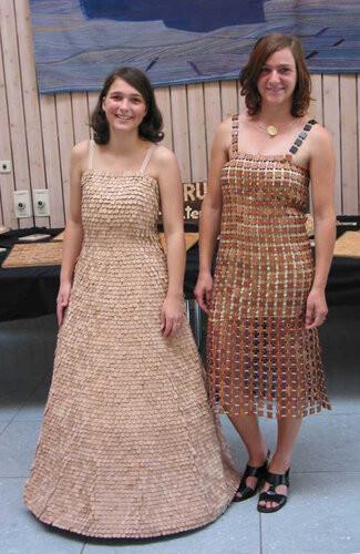 Zwei Schülerinnen präsentieren ihre aus Holzschindeln gefertigten Kleider.