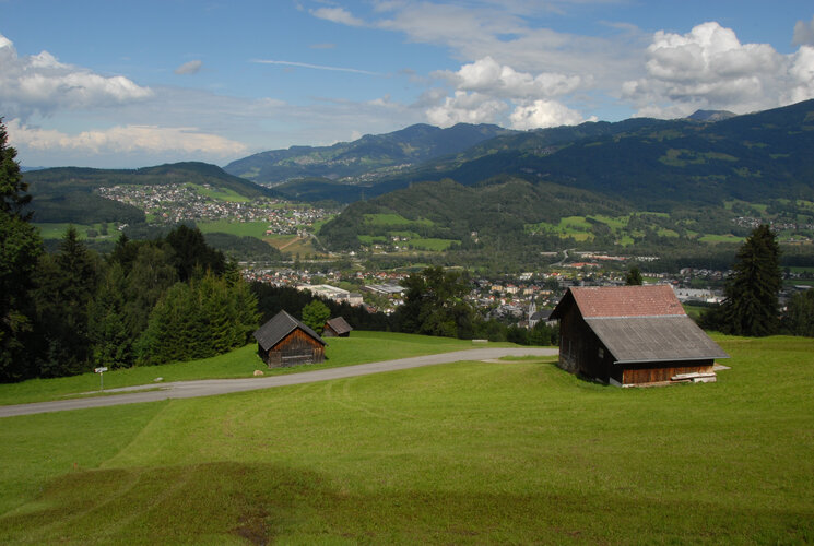 Berghäuser, im Hintergrund Ortschaft und Berge