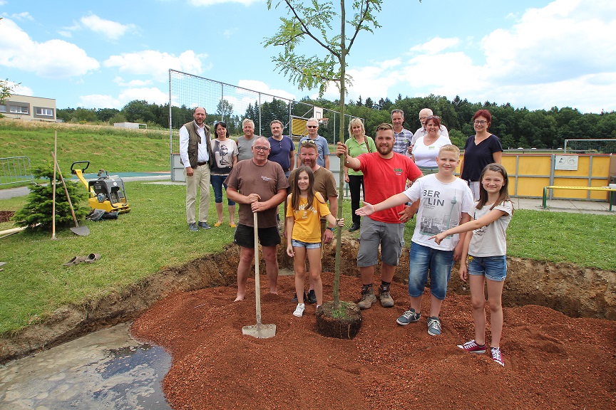 Menschen zeigen auf einen Baum.